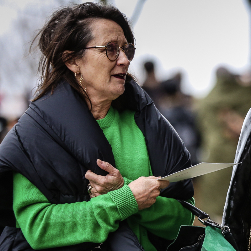 Stylish woman wearing a puffy outwear and a pullover and matching bag in bright green, one of the fashion colour trends to wear in fall 2020.