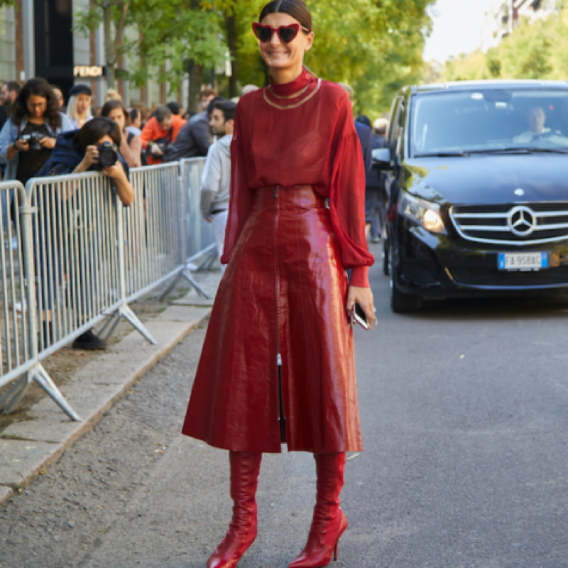 Giovanna Battaglia Engelbert wearing the monochrome trend, red blouse , leather skirt and boots, during Milan Fashion Week.