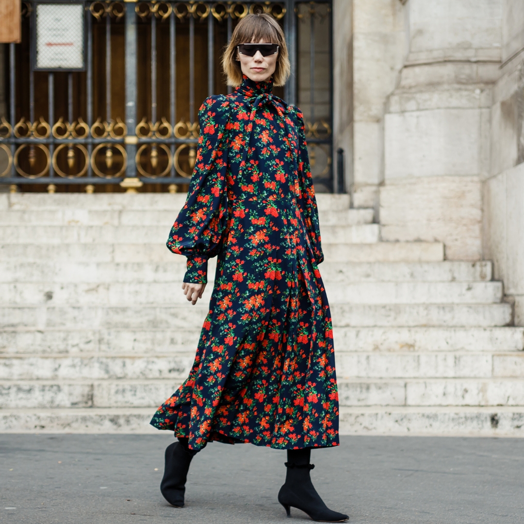 Paris street style- fashionista wearing a flower print dress with long sleeves, high collar and black boots