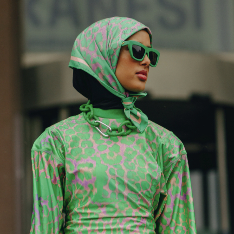 Woman wearing green apparel and accessories trend at Fashion Week.