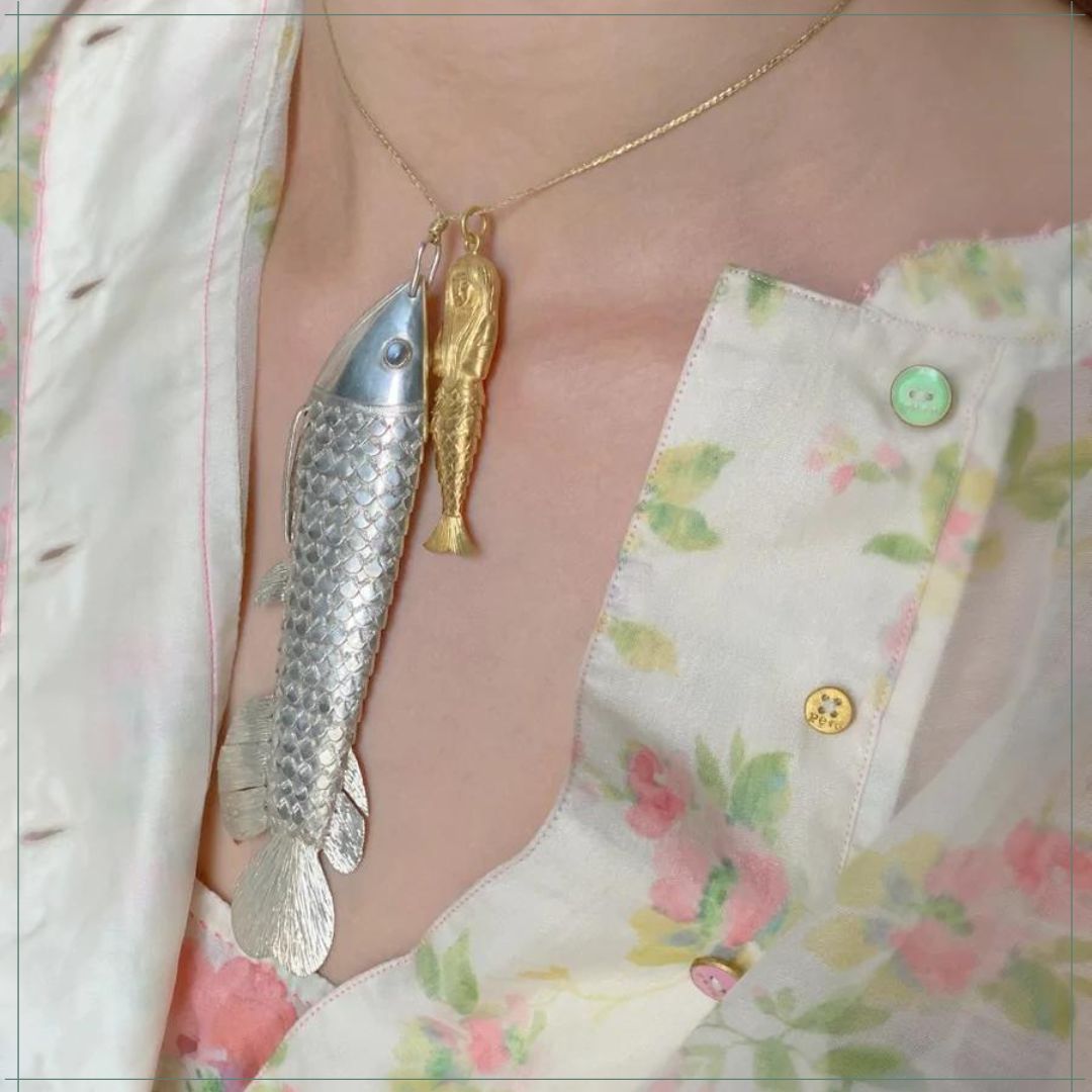 detail of a fish and a mermaid gold pendant from Pippa Small jewellery