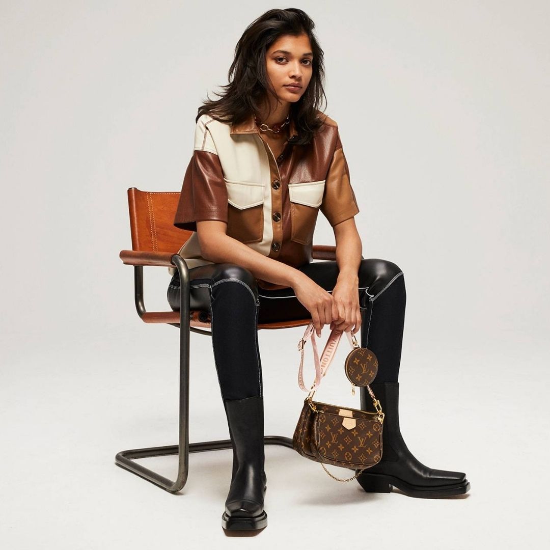woman sitting on a chair, wearing second hand clothes from Vestiaire Collective
