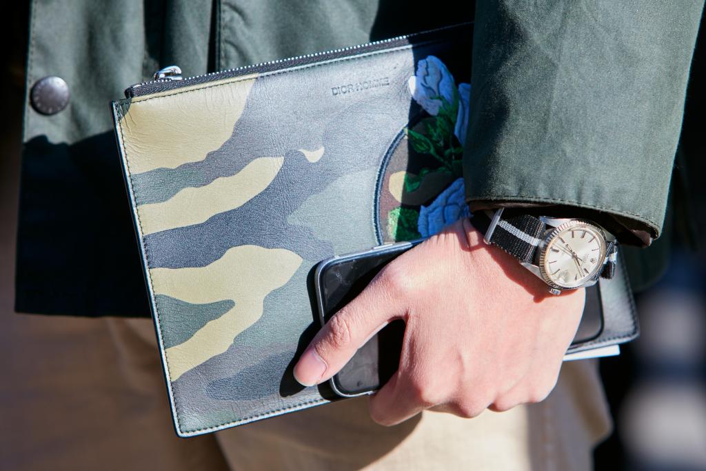 street style photo of a man wearing a luxury watch, holding a briefcase