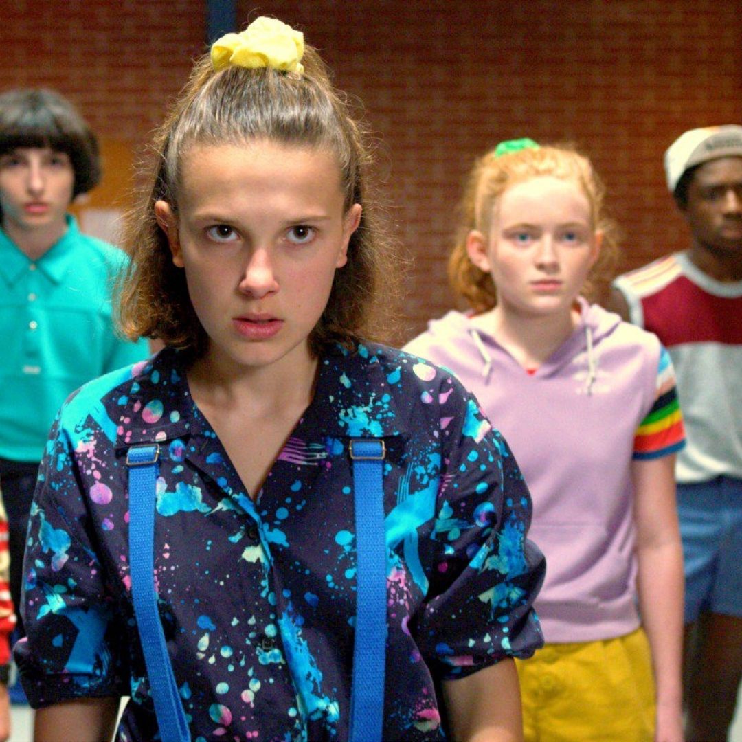Eleven of Strange things wearing 80s inspired yellow scrunchy