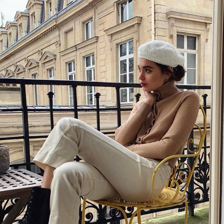 french girl sitting on the terrace of her apartment in Paris