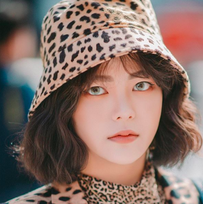 Korean street style fashionista wearing a animal print hat during Seoul Fashion Week