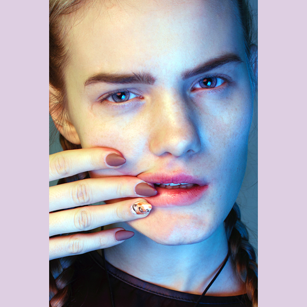 Beauty editorial with model with her fingers on her mouth showing the last nail colours for fall