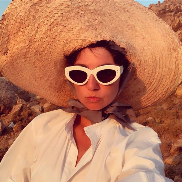 Eva Geraldine wearing a straw hat and white sunglasses
