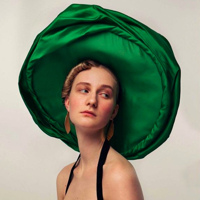 Model wearing a big fabric green hat