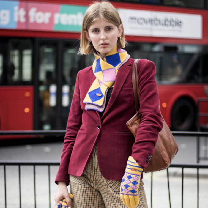 Woman wearing red blazer and colourful scarf and gloves, a comfortable office look.