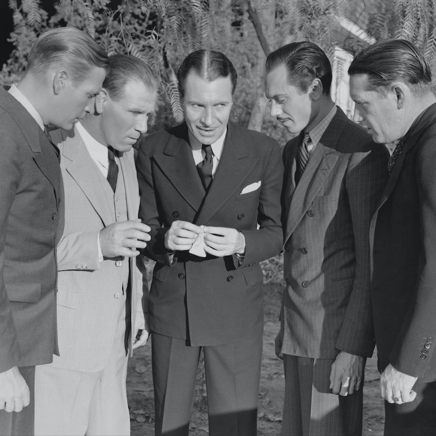 vintage photo showing a group of men curious to see what's in a jewellery box