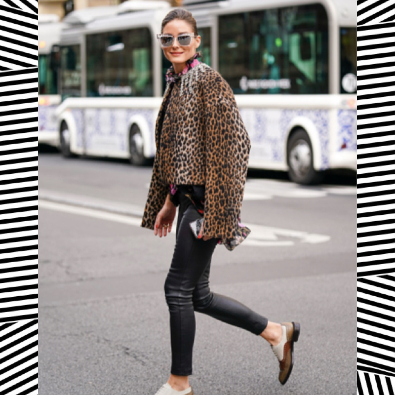 Street style photo of Olivia Palermo wearing leather leggings and leopard knitwear during fashion week.