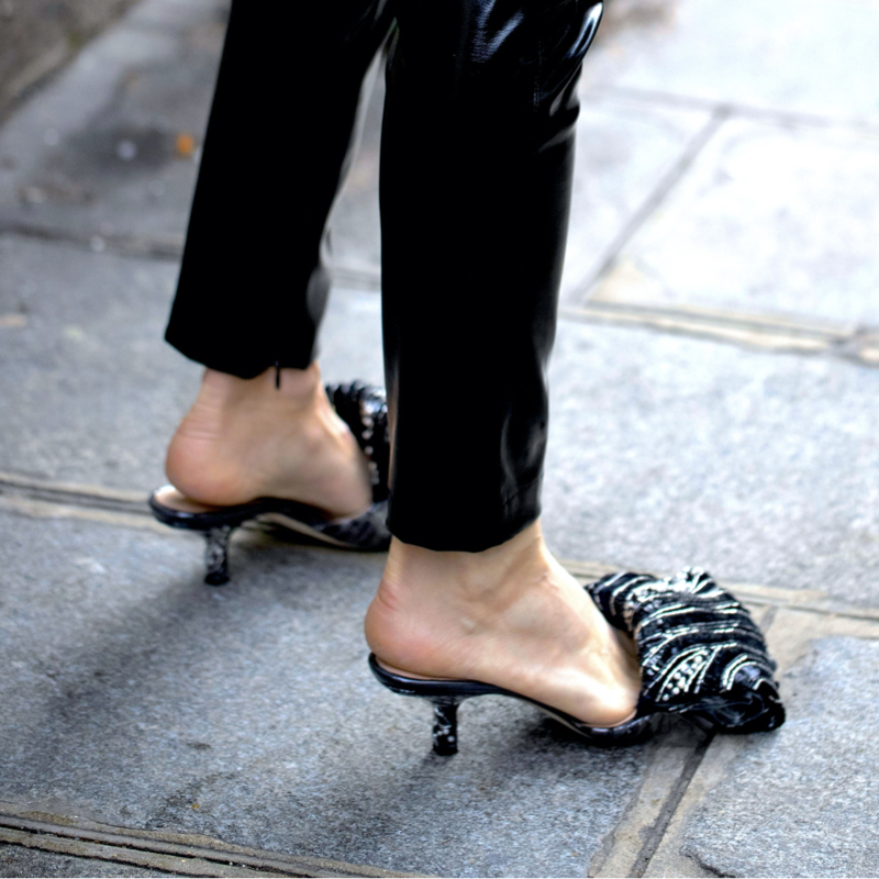 street style photo showing a detail of a woman wearing slim black jeans and Bottega Veneta mules