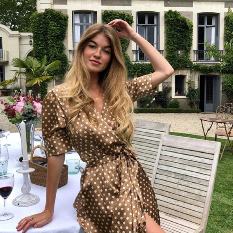 CONSTANCE ARNOULT wearing a polka dot wrap dress in a garden of a house in Tour, France