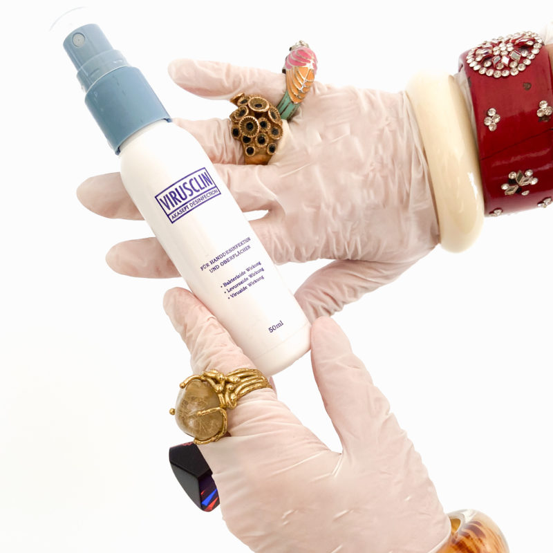 Hands with rubber gloves holding a package of disinfectant Virusclin
