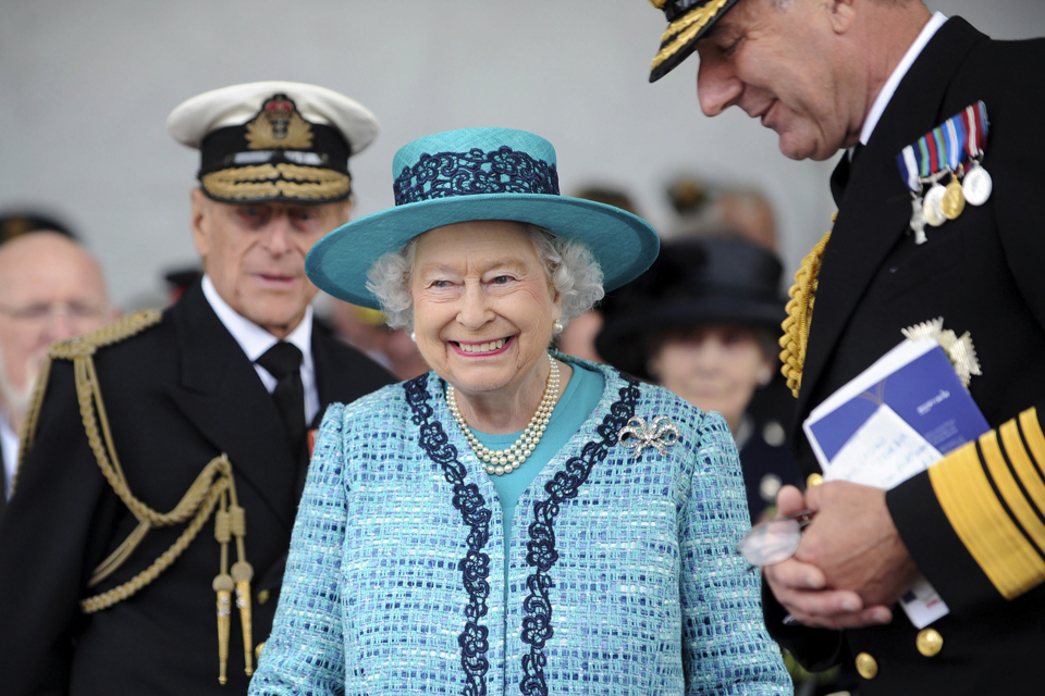 Queen Elizabeth naming HMS Queen Elizabeth wearing a green tweed skirt suit and a brooch