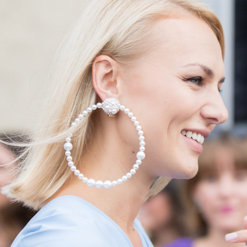 close up of a woman during fashion week wearing a big pearl creole earring