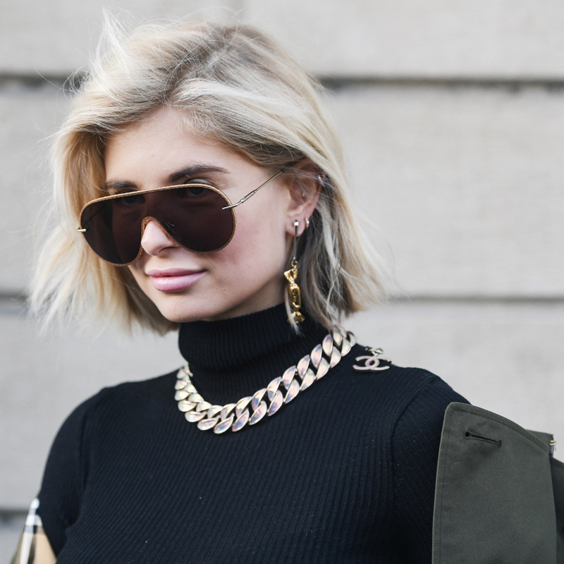 fashionista wearing a chunky chain necklace over a black turtleneck top
