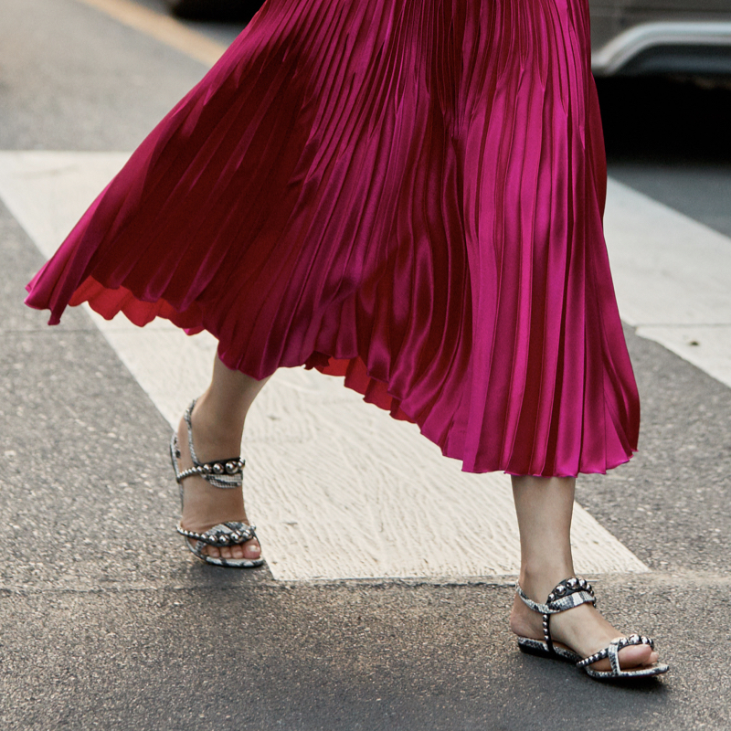 Street style photo of flat sandals and midi skirt for a chic look during Fashion Week.