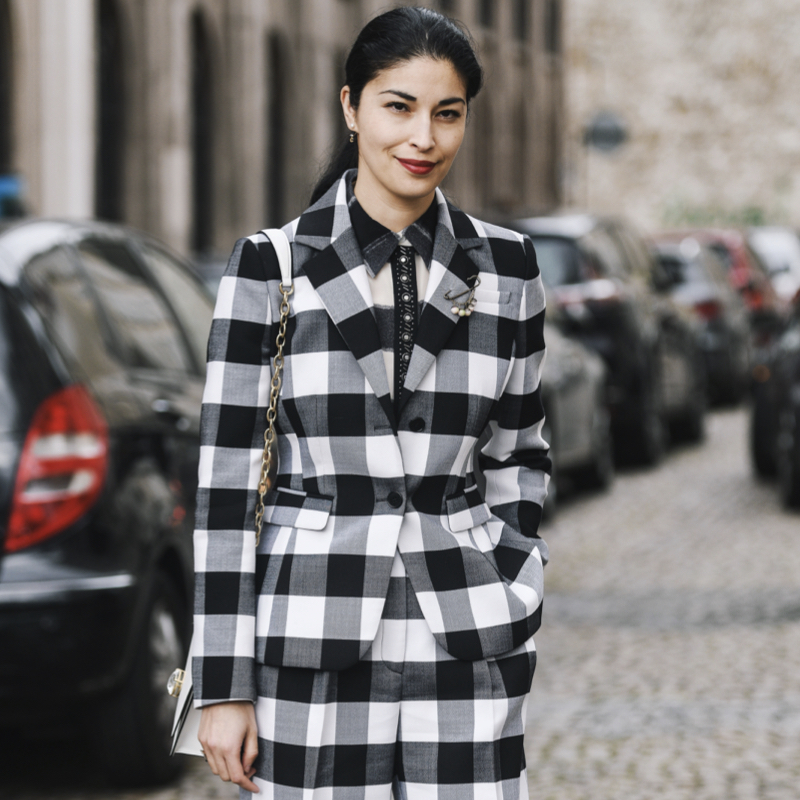 Woman wearing a black and white Vichy suit and matching Gingham shirt during Fashion Week.