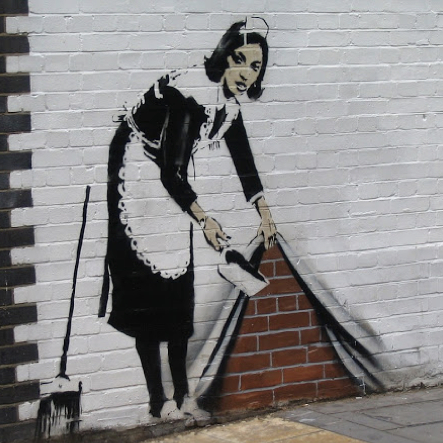 Famous street art piece by Bansky showing a cleaning lady putting the dirty under the carpet