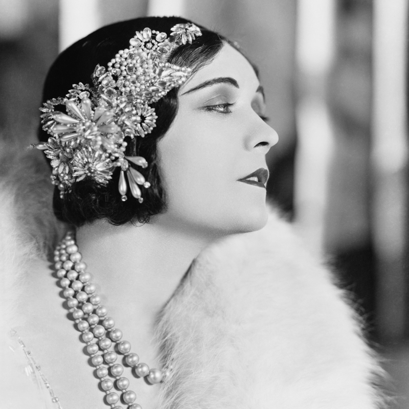Vintage image of elegant woman wearing stunning jewellery pieces that people are buying at online jewellery auctions.