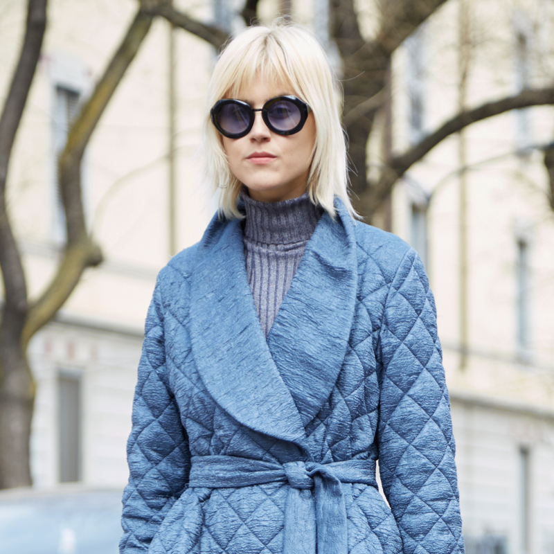 Stylish fashion-show goer wearing the winter quilted coat trend.