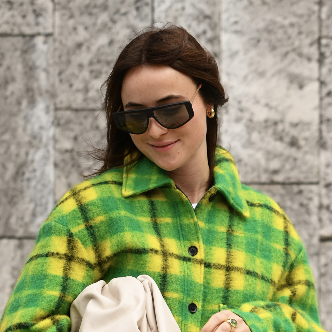 Woman wearing a neon yellow and green plaid winter jacket.