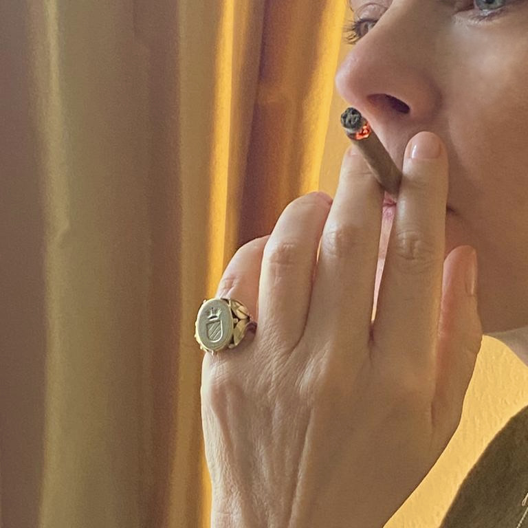 Selma Schönburg, editor-in-chief of Notorious Mag smoking a small cigar and wearing a gold signet ring with her family coat-of-arms.