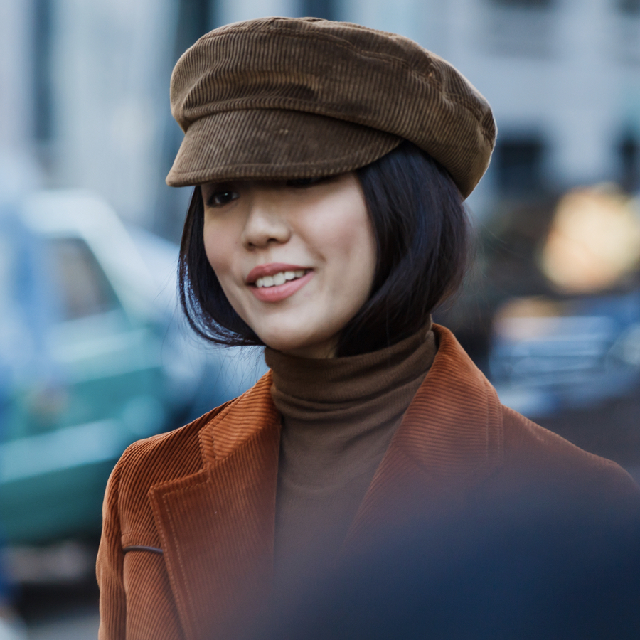 Woman wearing a fal outfit in chocolate brown; cap, blazer and turtle neck in matching dark brown colours.