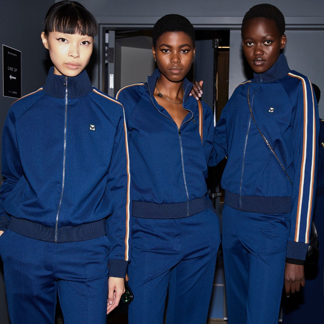 Models on backstage wearing tracksuits from Tory Burch