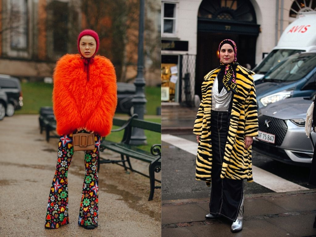 Two Danish girls in the streets of Copenhagen wearing a big fury red coat with floral pants-another wearing a tiger print coat with a scarf on her head - colourful street style at CPHFW 22