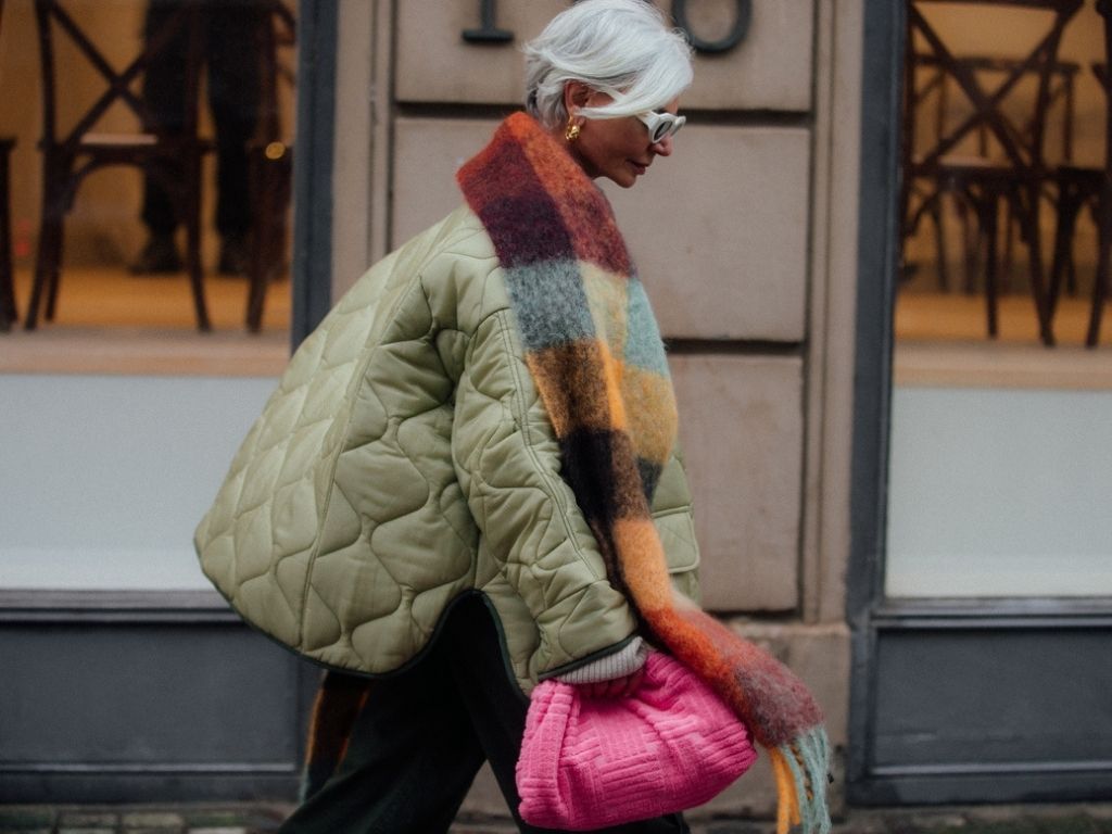 Grece Ghanem at Copenhagen Fashion Week AW22 wearing a puffy green coat, XL tartan foulard and a pink clutch