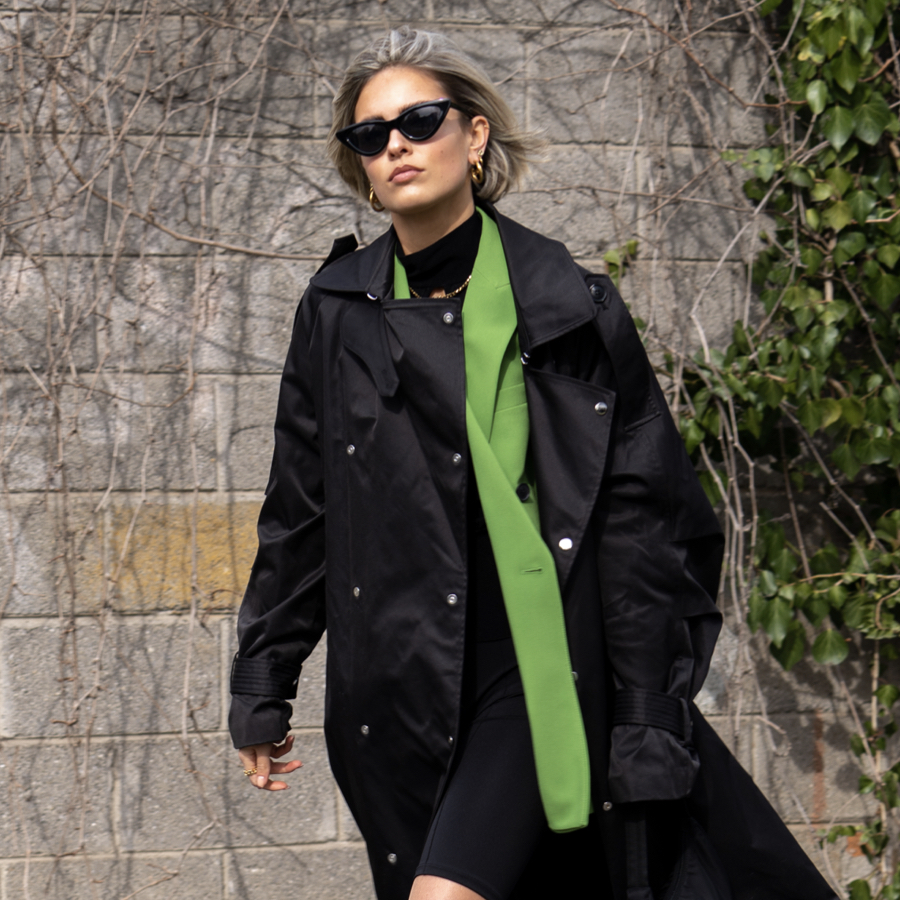 Woman wearing a green and black street style outfit at Milan Fashion Week.