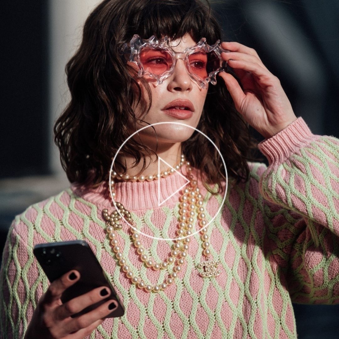 Fun and colourful fashionista at Copenhagen Fashion Week 22-wearing pink and green pullover and statement pink heart sunglasses