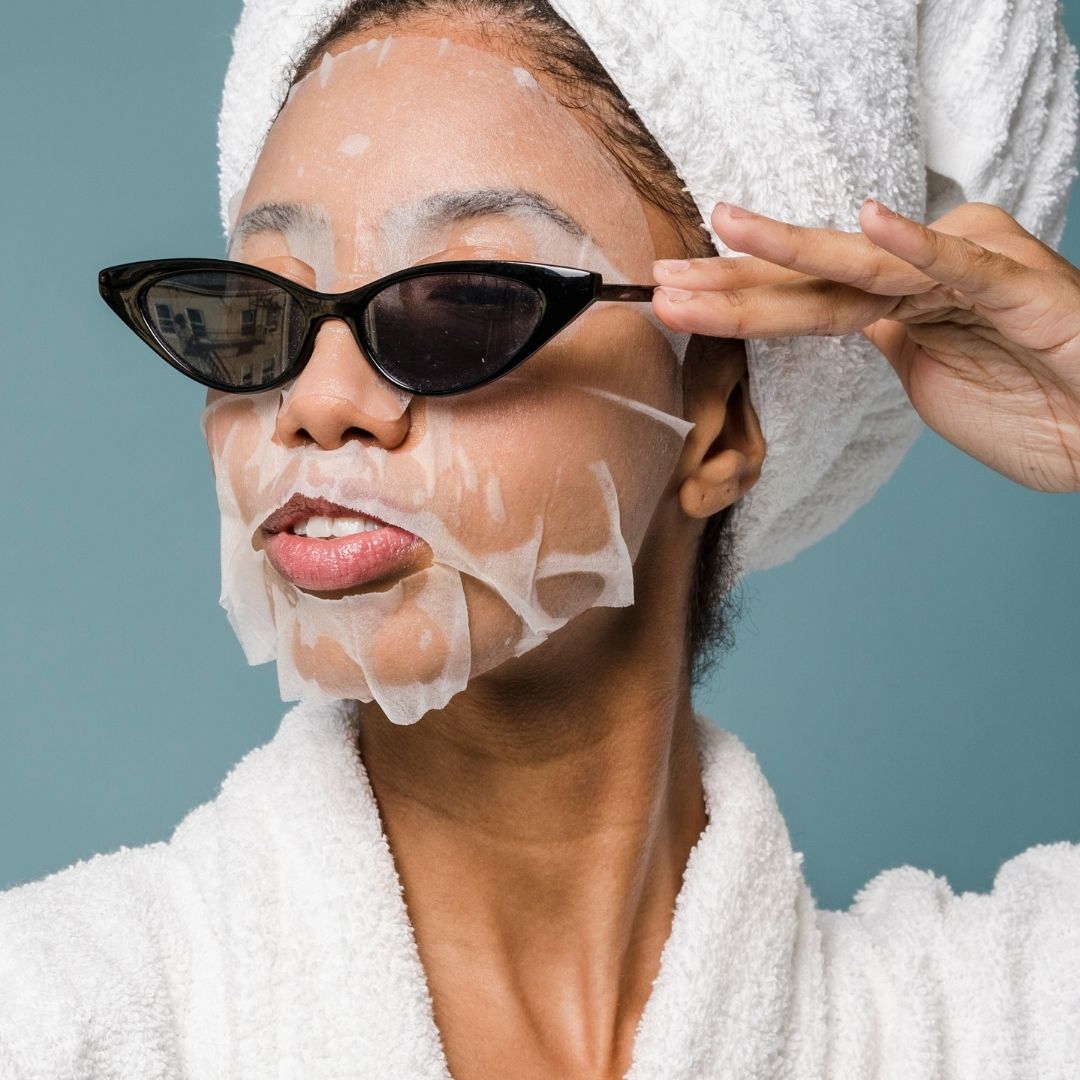 woman wearing a beauty face mask and sunglasses