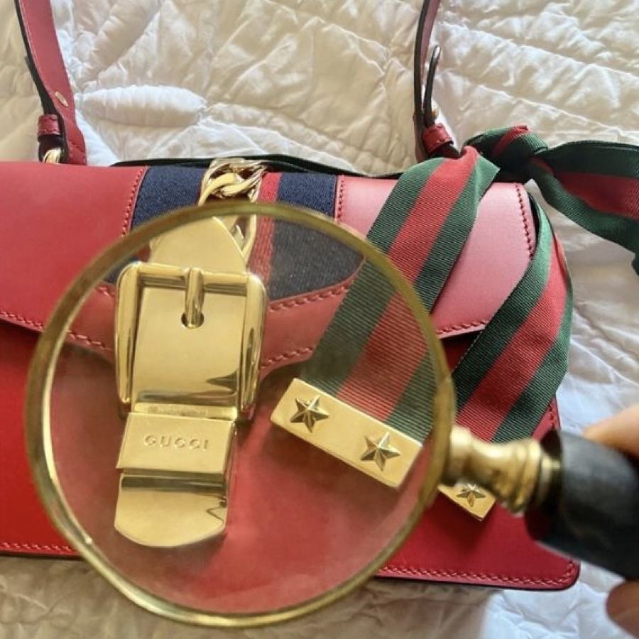 Red Gucci bag in detail under a glass magnifier