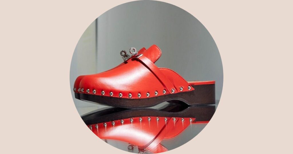 red hermes clog on a mirror floor