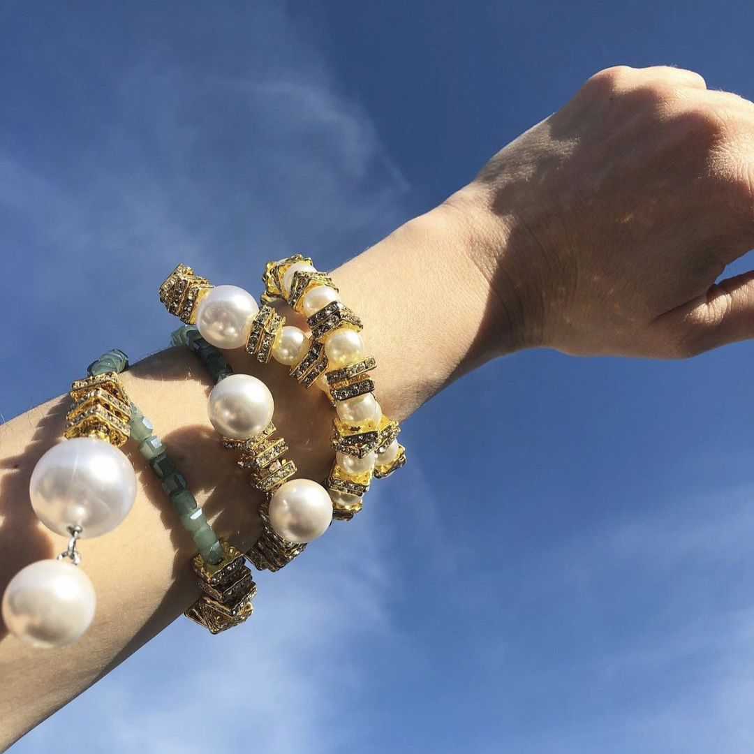 An arm wearing several jewellery pieces from the Scandinavian brand Pearl Octopuss.y