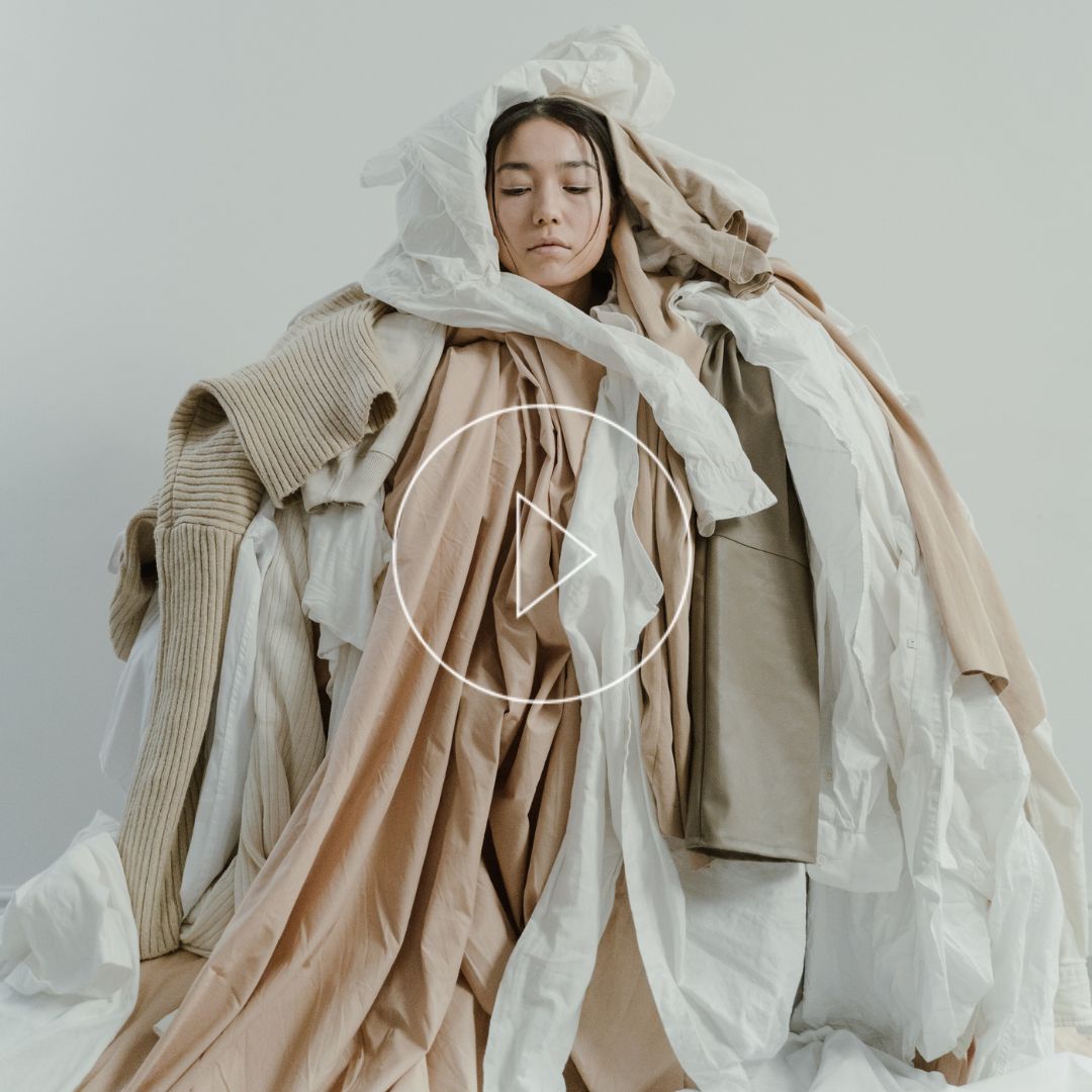 Woman covered over a pile of clothes