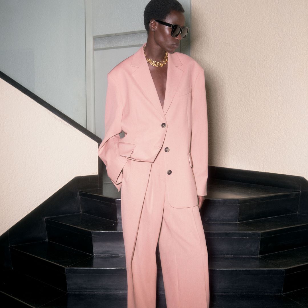 model from COS wearing a pink suit on a stairway