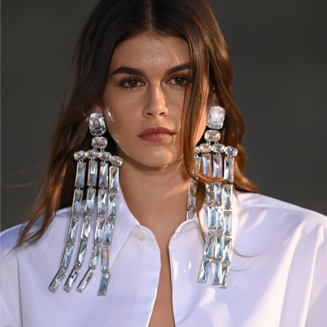 Kaia Gerber opening the Haute Couture Fall Winter 2023 for Valentino, wearing a white shirt and a oversized earrings