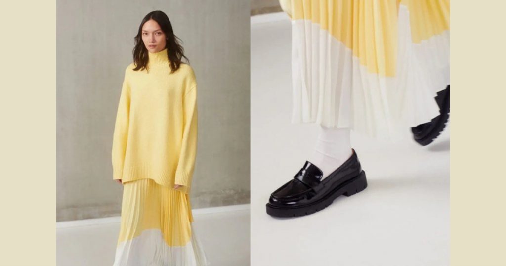 Model wearing a yellow pullover and a yellow maxi skirt paired with a black mocassim from Clare Waight Keller