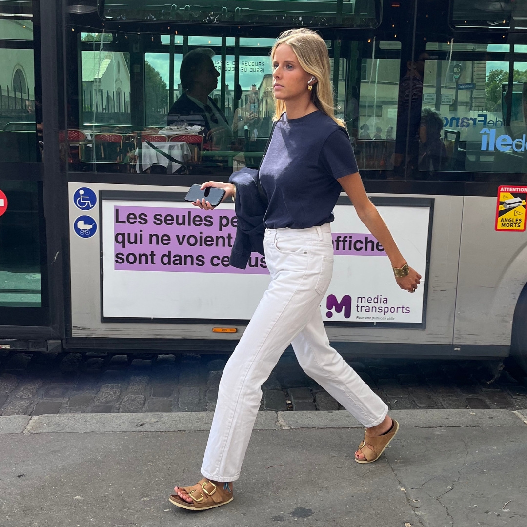 Parisian walking in the streets wearing a white jeans