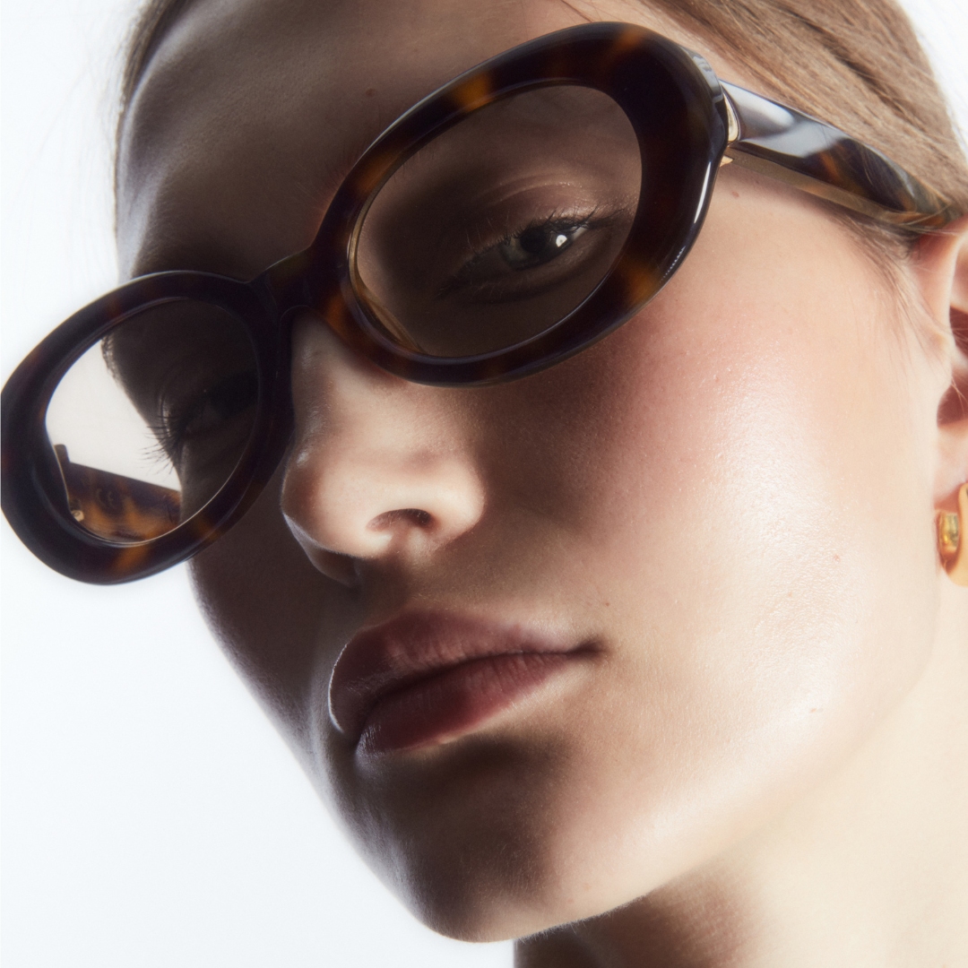 photo of a female model wearing a thick round frame sunglasses from COS x Linda Farrow