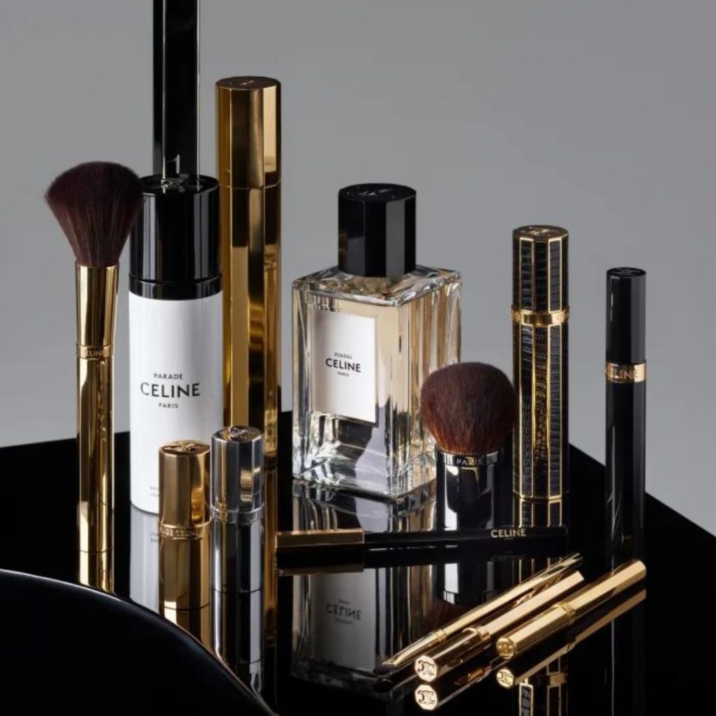 perfume and makeup products from celine beauté photographed on a shine black table