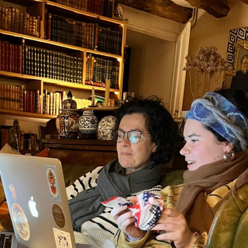 mother and a young daughter in a library, surfing in the internet.